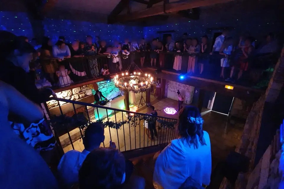 Piste de danse et stand DJ en salle en pierre, éclairage chandelier et laser